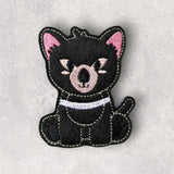 Black and white handmade tasmanian devil finger puppet displayed flat lay on a marble background.