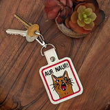 Close‑up of embroidered cat meme keychain with surprised expression