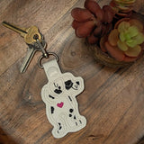 Close‑up of embroidered Dalmatian butt keychain with heart detail