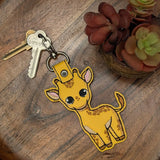 Close‑up of embroidered yellow giraffe keychain with big eyes