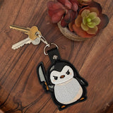 Close‑up of embroidered knife penguin keychain with intense expression