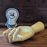 Embroidered witch halloween finger puppet made from felt displayed on a wooden mannequin hand. 