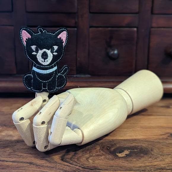 Embroidered Tasmanian Devil finger puppet made from felt displayed on a wooden mannequin hand. 