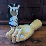 Embroidered zebra finger puppet made from felt displayed on a wooden mannequin hand. 