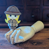 Embroidered female safari guide finger puppet made from felt displayed on a wooden mannequin hand. 