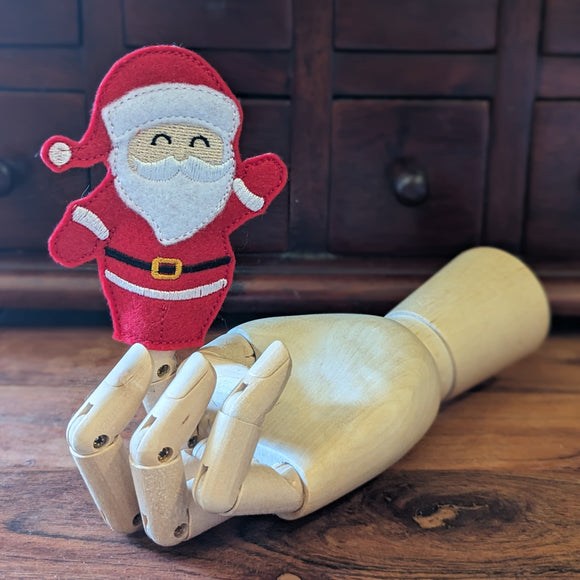 Embroidered Santa finger puppet made from felt displayed on a wooden mannequin hand. 