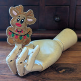 Embroidered Rudolph finger puppet made from felt displayed on a wooden mannequin hand. 
