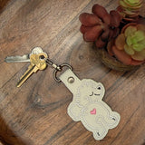 Close‑up of embroidered poodle butt keychain with heart detail
