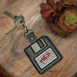 Close‑up of embroidered retro floppy disk keychain