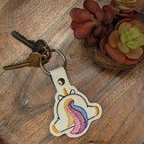 Close‑up of embroidered unicorn butt keychain with rainbow mane