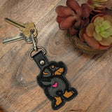 Close‑up of embroidered Rottweiler keychain with heart detail