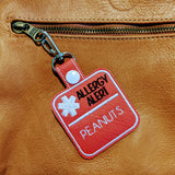 Close‑up of embroidered allergy alert keyring.